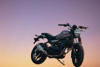 Royal Enfield Guerrilla 450 in the new Peix Bronze color, featuring a sleek matte finish. The motorcycle is priced at Rs. 2.49 lakh and comes with a 452cc liquid-cooled engine, dual-channel ABS, and modern tech features. Perfect for urban and highway rides.