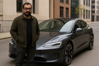 अनुराग कश्यप अपनी नई डार्क ग्रे इलेक्ट्रिक कार के पास खड़े हैं, जो एक शहरी सड़क पर खड़ी है।