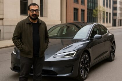 अनुराग कश्यप अपनी नई डार्क ग्रे इलेक्ट्रिक कार के पास खड़े हैं, जो एक शहरी सड़क पर खड़ी है।