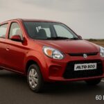 लाल रंग की Maruti Suzuki Alto 800 दो लेन वाली सड़क पर खड़ी है, बैकग्राउंड में खुला मैदान और बादलों से ढका आसमान नजर आ रहा है।