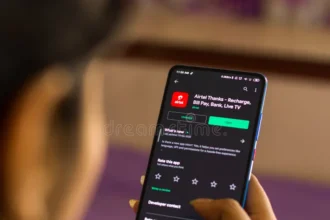 मोबाइल रिचार्ज और बिल पेमेंट सेंटर में ग्राहक सेवा लेते हुए व्यक्ति