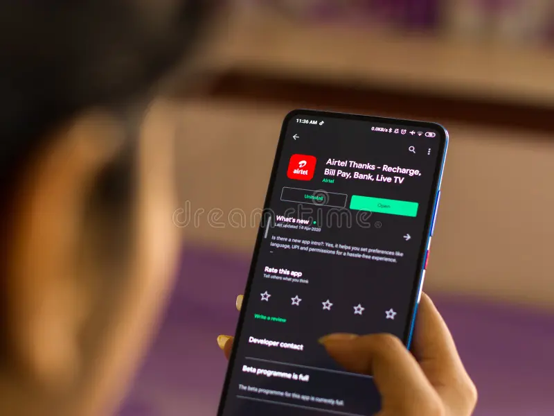 मोबाइल रिचार्ज और बिल पेमेंट सेंटर में ग्राहक सेवा लेते हुए व्यक्ति